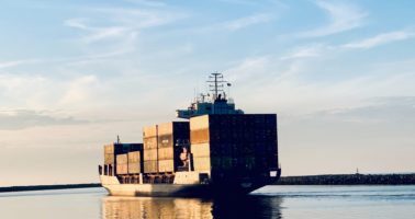 cargo ship on sea under blue sky during daytime